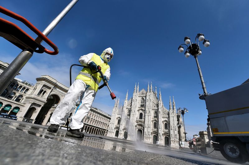 &copy; Reuters. Un trabajador con ropa de protección desinfecta la plaza del Duomo, durante el brote de coronavirus (COVID-19) en el centro de Milán