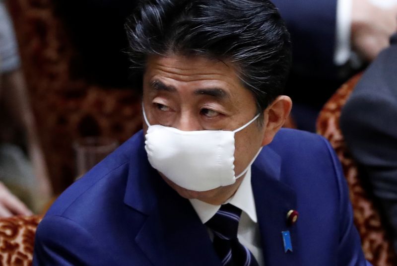 © Reuters. El primer ministro de Japón, Shinzo Abe, usa una máscara facial protectora mientras asiste a una sesión parlamentaria de la cámara alta