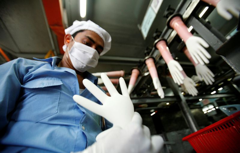 &copy; Reuters. FILE PHOTO: A worker inspects a glove at the factory of Top Glove in Kelang
