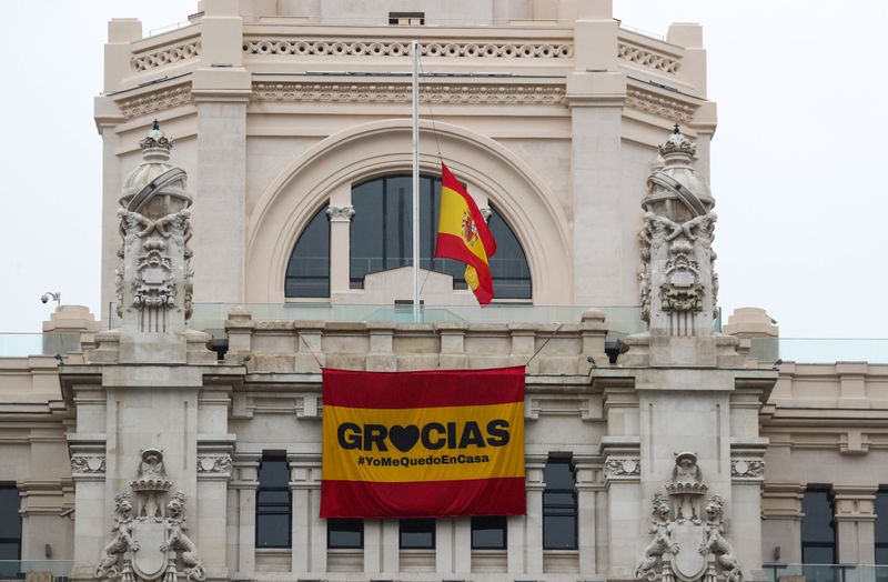 &copy; Reuters. La bandiera spagnola a mezz&apos;asta a Madrid, insieme a un&apos;altra bandiera che invita i cittadini a restare a casa