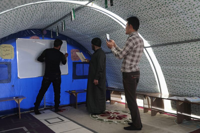 &copy; Reuters. Ahmed Hadaja records with other teachers a video lesson for students in Atmeh camp