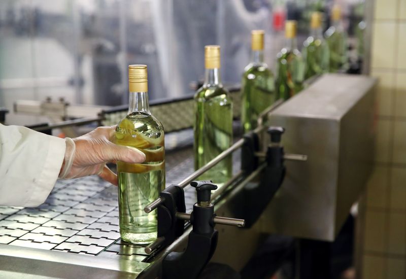 &copy; Reuters. Staff lines a bottle into a labeller at Swiss distiller Morand in Martigny