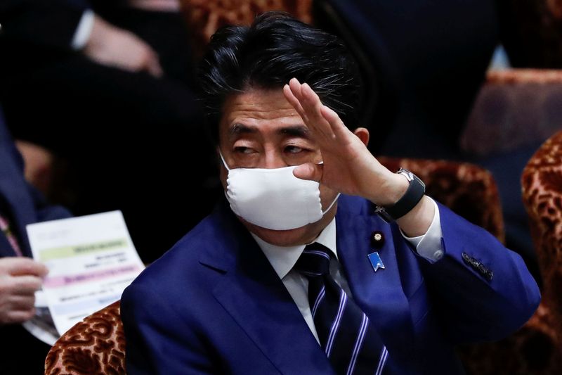 &copy; Reuters. Japan&apos;s Prime Minister Shinzo Abe wears a protective face mask as he attends an upper house parliamentary session