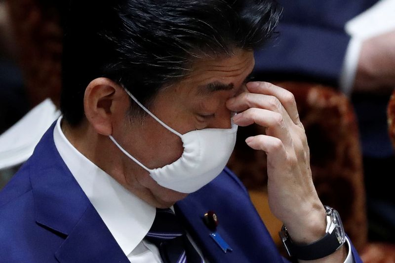 &copy; Reuters. Japan&apos;s Prime Minister Shinzo Abe wears a protective face mask as he attends an upper house parliamentary session