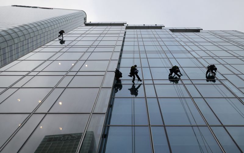 &copy; Reuters. Workers clean the windows on the KPMG building in London&apos;s Canary Wharf financial district in London