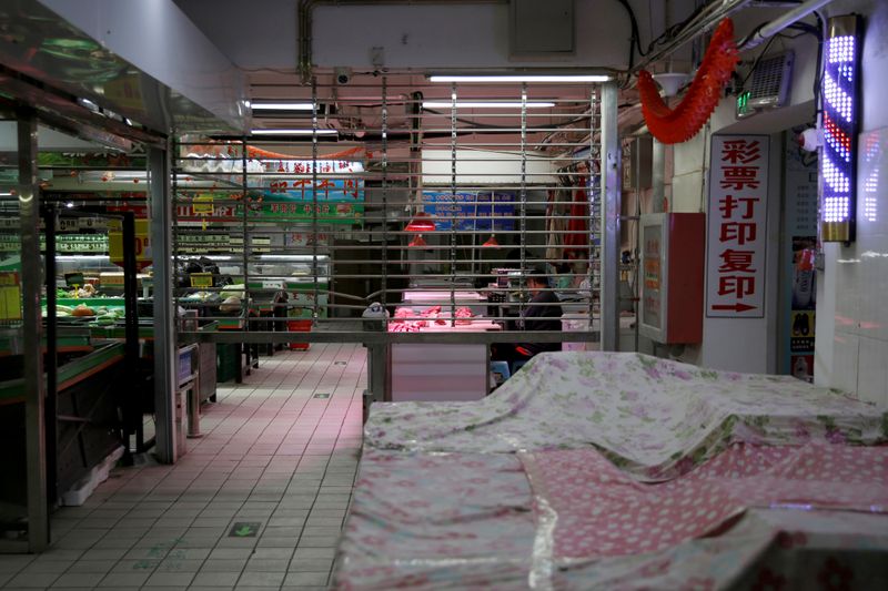 &copy; Reuters. A man sits at a meat stall market inside a partially closed shop, as the country is hit by an outbreak of the novel coronavirus disease (COVID-19), in Beijing