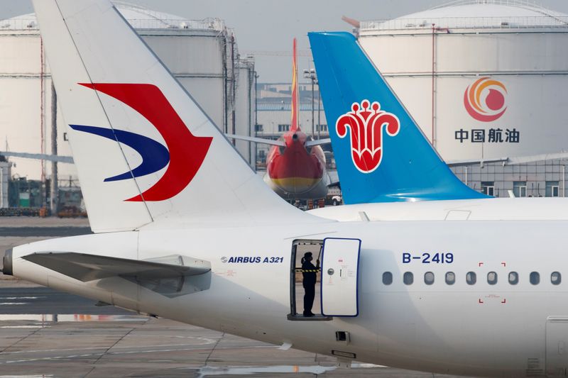 © Reuters. FOTO DE ARCHIVO: Un trabajador del personal de tierra limpia un avión de pasajeros estacionado en el Aeropuerto Internacional Capital de Beijing mientras el país se ve afectado por un brote del nuevo coronavirus