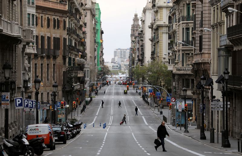 &copy; Reuters. La gente camina por la calle Via Laietana durante el brote de la enfermedad coronavirus (COVID-19), en Barcelona, España