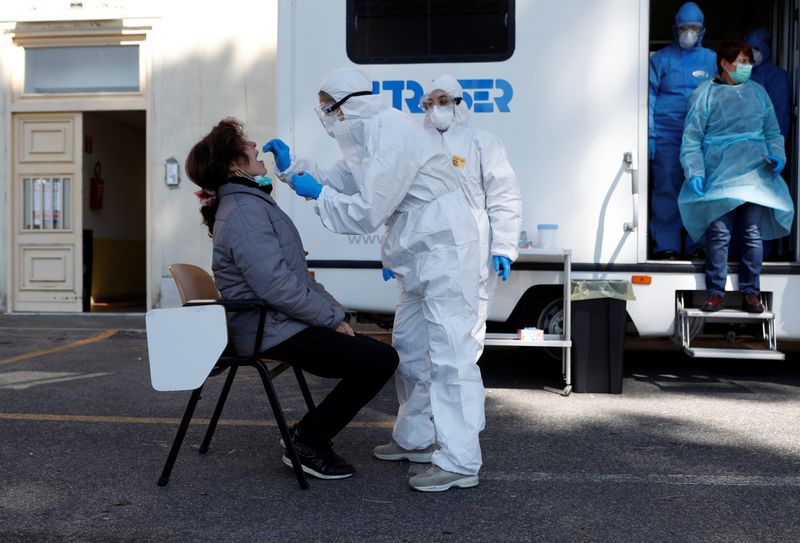 &copy; Reuters. Alcuni operatori sanitari in tuta protettiva eseguono dei controlli a Roma