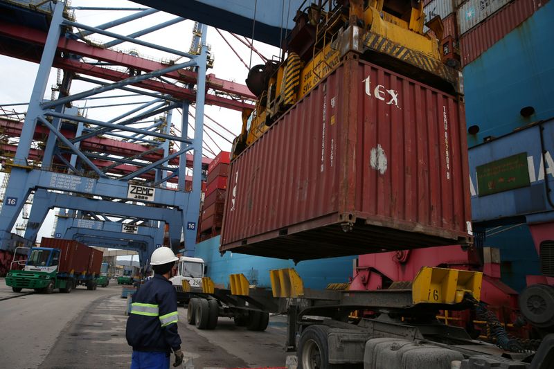 &copy; Reuters. A worker observes a container being placed on top of a truck at the Port of Santos in Santos