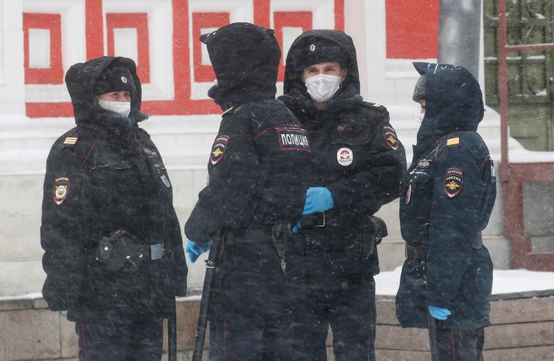 &copy; Reuters. Полицейские в защитных масках во время патрулирования улиц в Москве
