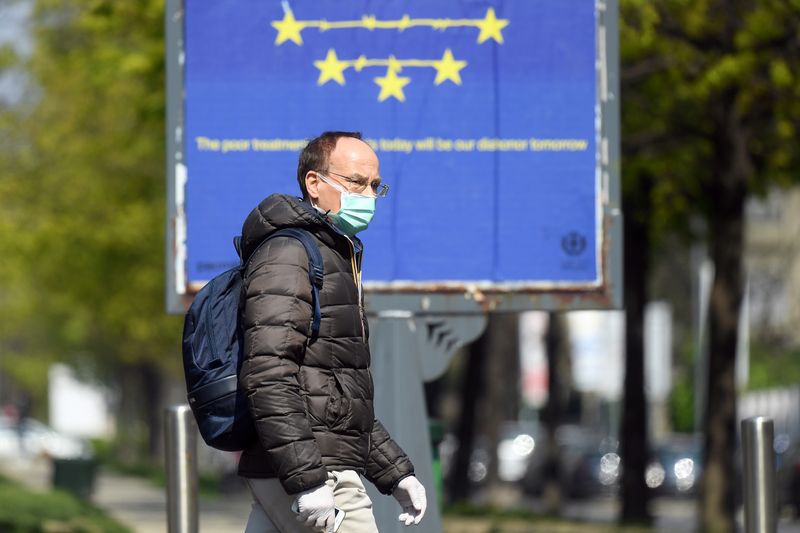 &copy; Reuters. Homem com máscara de proteção caminha em Milão