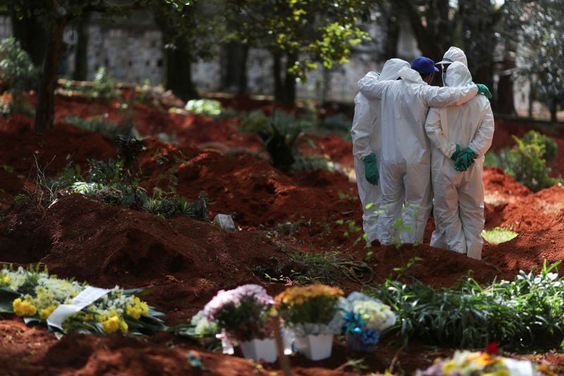© Reuters. Sepultureros con trajes protectores se reúnen en el cementerio de Vila Formosa, el cementerio más grande de Brasil, durante el brote del coronavirus en São Paulo, Brasil