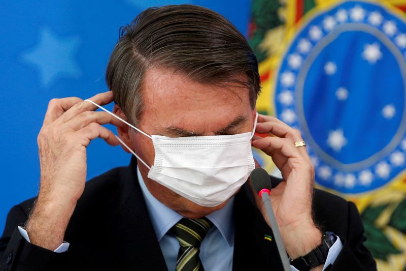 &copy; Reuters. FILE PHOTO: Brazil&apos;s Jair Bolsonaro adjusts his protective face mask during a news conference to announce measures to curb the spread of the coronavirus disease (COVID-19) in Brasilia