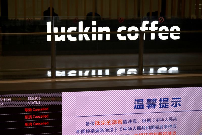 &copy; Reuters. FILE PHOTO: Sign of Luckin Coffee is seen behind an information board showing cancelled flights, at the Beijing Daxing International Airport, as the country is hit by an outbreak of the novel coronavirus, in Beijing