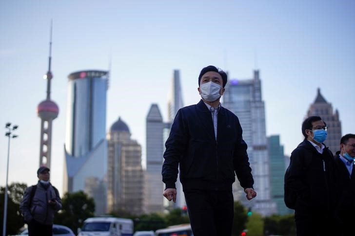 © Reuters. FOTO DE ARCHIVO: Las personas usan mascarillas protectoras, luego de un brote de la nueva enfermedad por coronavirus (COVID-19), en el distrito financiero de Lujiazui en Shanghai