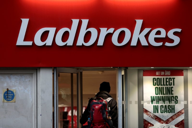 &copy; Reuters. FILE PHOTO: A man walks into a branch of a Ladbrokes bookmaker in London