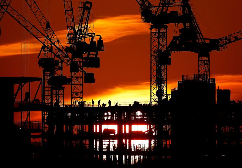 &copy; Reuters. FILE PHOTO: Workers are seen as the sun sets behind a construction site in London