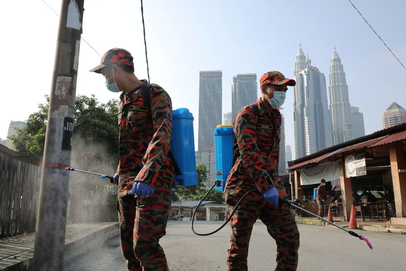 &copy; Reuters. Firefighters spray disinfectant on a street during the movement control order due to the outbreak of the coronavirus disease (COVID-19), in Kuala Lumpur