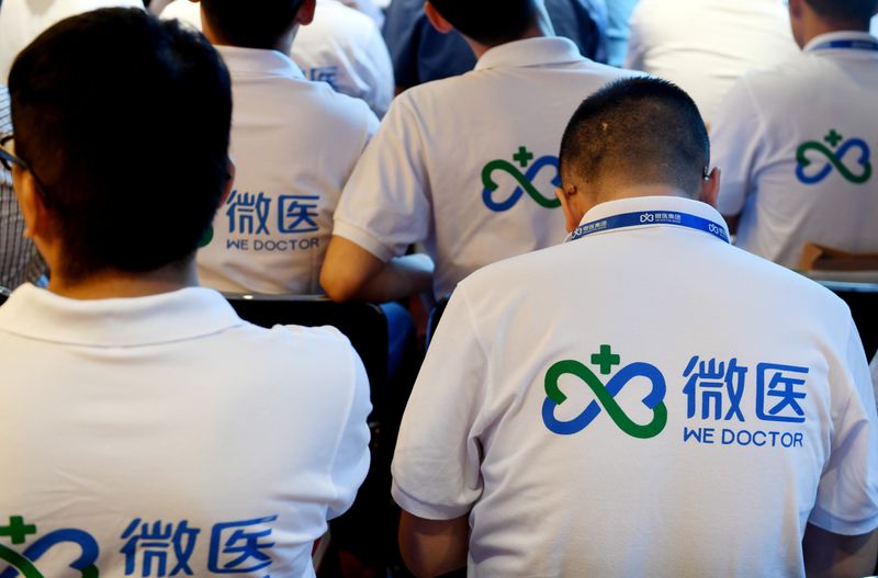 &copy; Reuters. Men wearing shirts bearing the logo of online healthcare solutions platform WeDoctor attend a signing ceremony in Zhengzhou