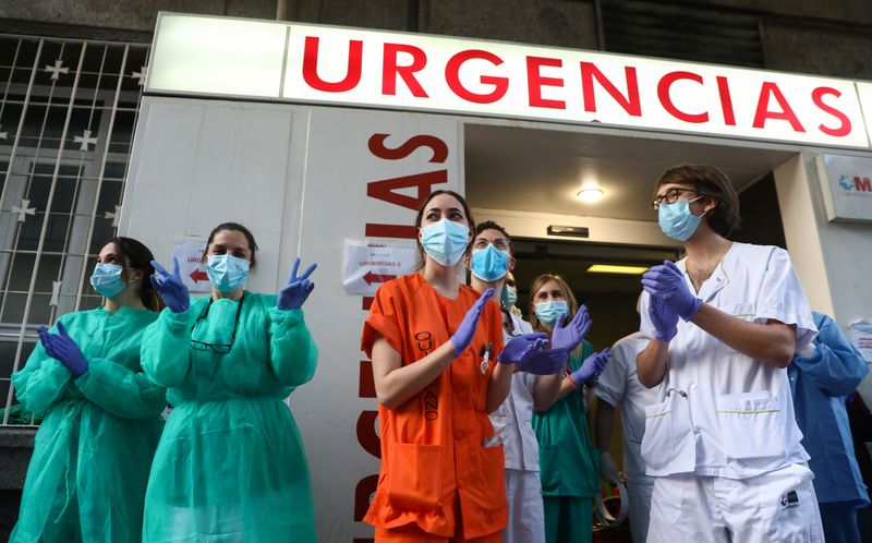 © Reuters. Profissionais de saúde de hospital em Madri reagem a aplausos de vizinhos