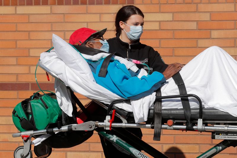 &copy; Reuters. Healthcare worker wheels patient on stretcher into Wyckoff Heights Medical Center during outbreak of coronavirus disease (COVID-19) in New York