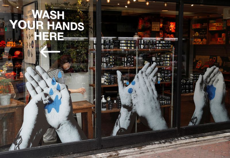 &copy; Reuters. FILE PHOTO: A shop employee wearing a protective face mask, following an outbreak of the coronavirus disease (COVID-19), prepares antiseptic solution at Shibuya shopping and amusement district in Tokyo