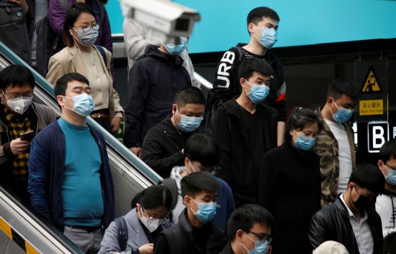 &copy; Reuters. Personas con máscaras faciales en una escalera mecánica dentro de una estación de metro durante la hora punta de la mañana en Pekín, mientras la propagación de la nueva enfermedad coronavirus (COVID-19) continúa en el país