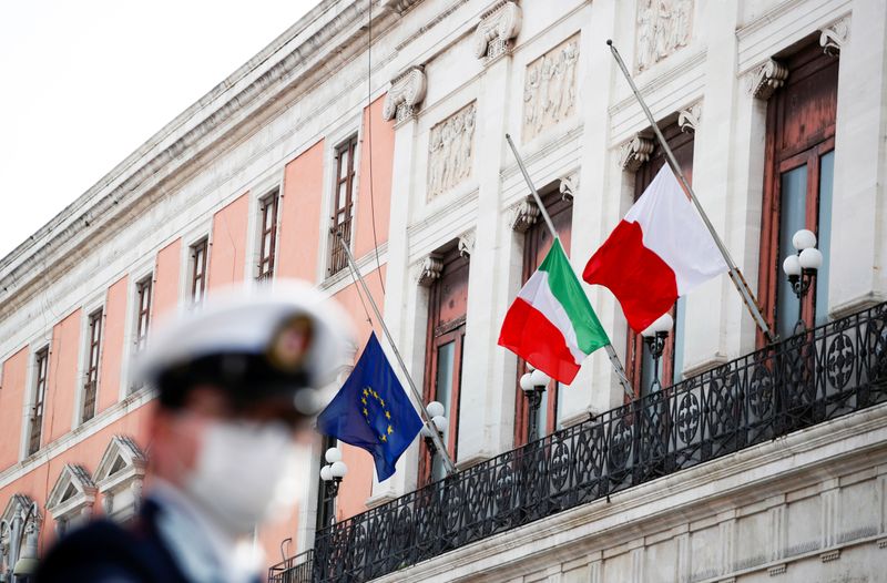 © Reuters. Las banderas de Italia, la Unión Europea y Bari ondean a media asta para honrar a los muertos del país a causa de la enfermedad coronavirus (COVID-19), en Bari, Italia, el 31 de marzo de 2020