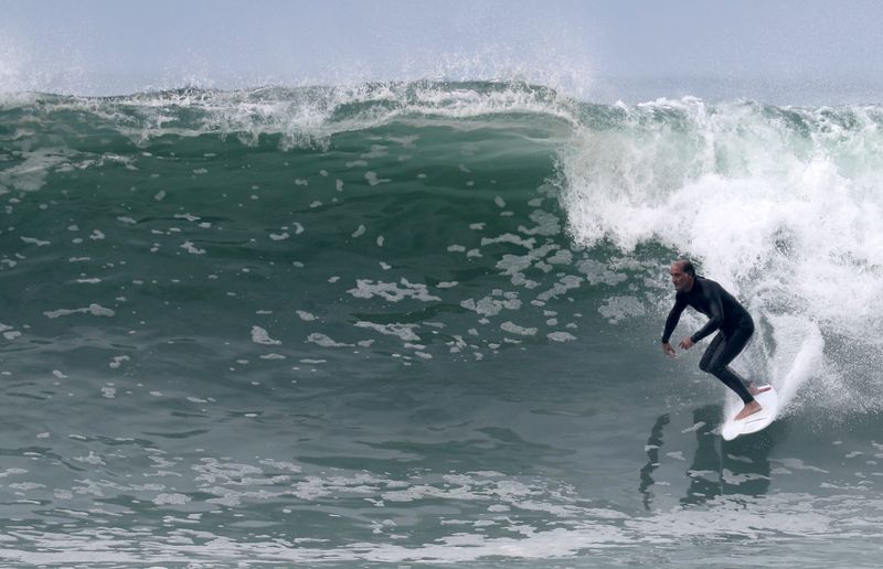 © Reuters. A surfer rides a wave on Copacabana beach, amid the coronavirus disease (COVID-19) outbreak, in Rio de Janeiro