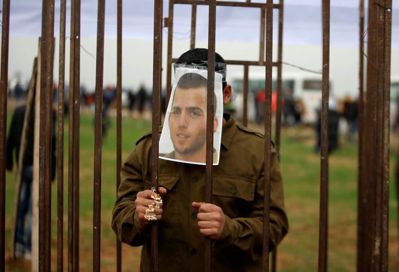 © Reuters. FILE PHOTO: Palestinian man playing the role of Israeli soldier Oron Shaul stands in a mock jail during a rally in solidarity with Palestinian prisoners held in Israeli jails, in the northern Gaza Strip