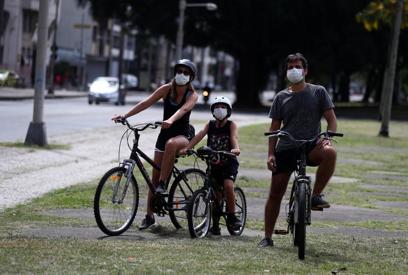 &copy; Reuters. Família com máscara de proteção em praça do Rio de Janeiro