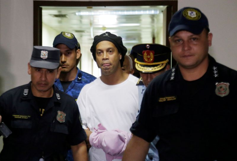 &copy; Reuters. Ronaldinho é escoltado pela polícia em tribunal do Paraguai