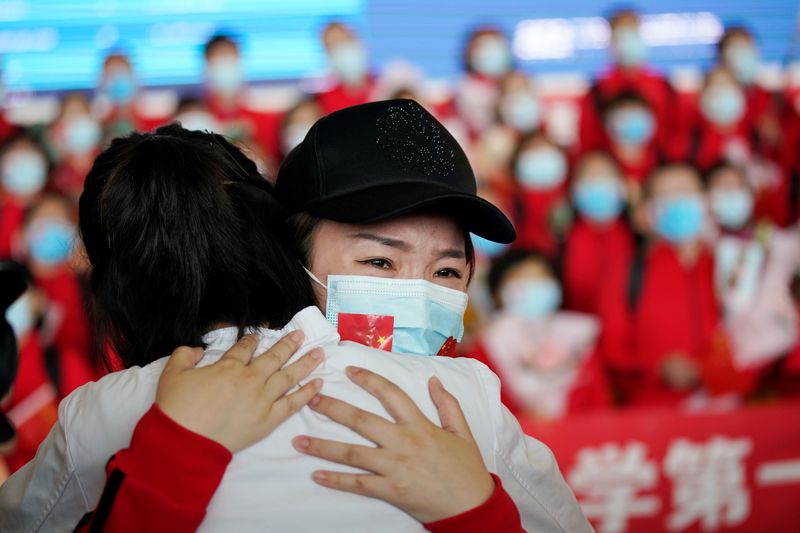 &copy; Reuters. Agente de saúde se emociona ao abraçar colega após fim de isolamento em Wuhan, epicentro inicial do novo coronavírus