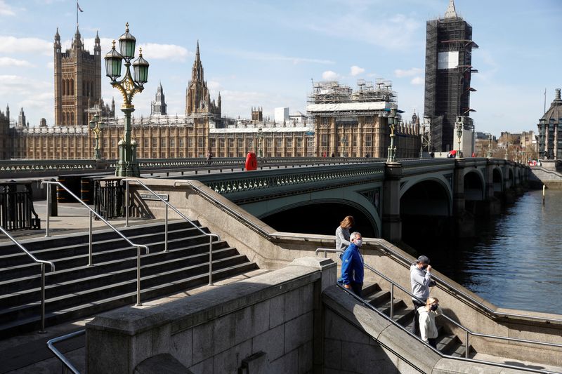 &copy; Reuters. Pessoas com máscaras de proteção na ponte de Westminster, em Londres