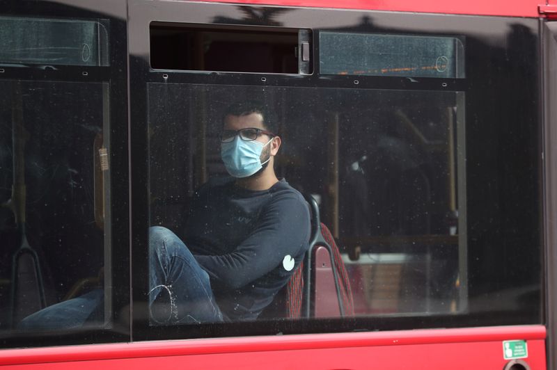 &copy; Reuters. Passageiro com máscara de proteção contra novo coronavírus observa ruas de Londres pela janela de ônibus