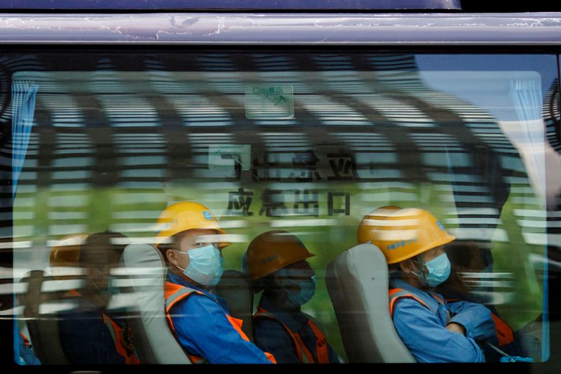 &copy; Reuters. Workers leave a construction site at the end of their shift in the Central Business District in Beijing