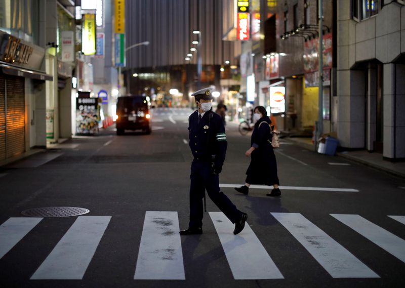 &copy; Reuters. FILE PHOTO:   A police officer wearing a protective face mask patrols on the street following the coronavirus disease outbreak in Tokyo