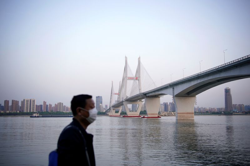 &copy; Reuters. Un hombre con una mascarilla bajo un puente del río Yangtsé en Wuhan después de que se levantara el bloqueo en Wuhan