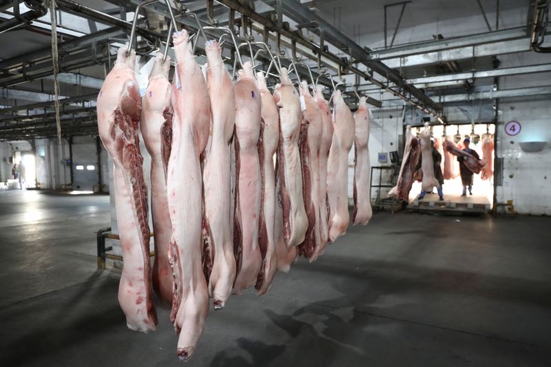 &copy; Reuters. FILE PHOTO:  Employees work at a pig slaughtering and pork processing plant in Huaian