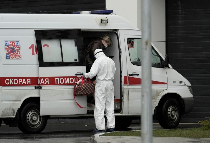 &copy; Reuters. A woman gets out of an ambulance upon the arrival at a hospital for patients infected with the coronavirus disease on the outskirts of Moscow