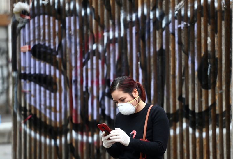 © Reuters. FILE PHOTO: A woman checks her mobile phone amid the coronavirus outbreak in Madrid