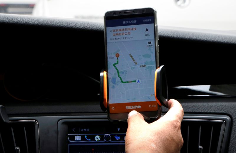 © Reuters. Motorista da Didi Chuxing checa informações em celular em Pequim, China