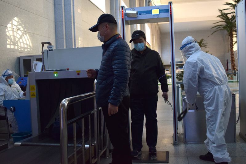 &copy; Reuters. Pasajeros con mascarillas pasan por un control de seguridad en la estación de tren de Suifenhe, en Suifenhe, una ciudad fronteriza con Rusia en la provincia china de Heilongjiang