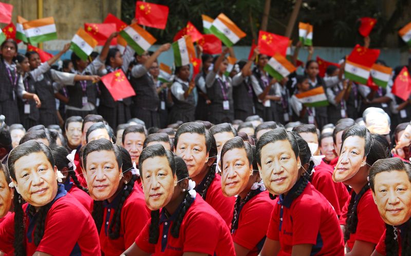 &copy; Reuters. FILE PHOTO: Students wear masks of China&apos;s President Xi Jinping as other waves national flags of India and China, ahead of the informal summit with India’s Prime Minister Narendra Modi, at a school in Chennai