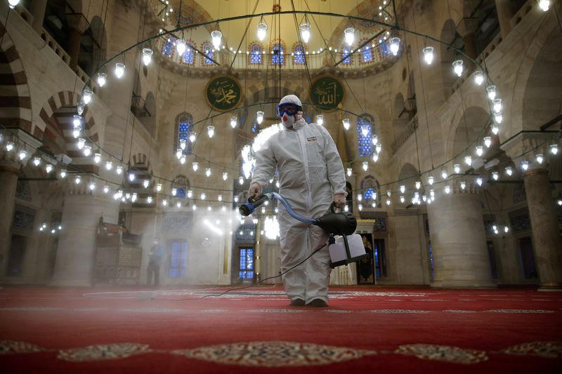&copy; Reuters. A municipality worker in a protective suit disinfects Kilic Ali Pasha Mosque due to coronavirus concerns in Istanbul, Turkey