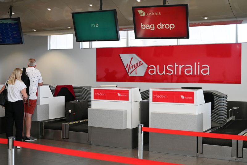 &copy; Reuters. FILE PHOTO:  Travelers stand at a Virgin Australia Airlines counter at Kingsford Smith International Airport in Sydney