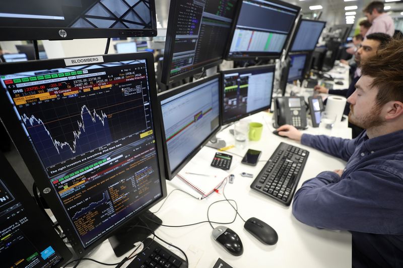 &copy; Reuters. FILE PHOTO: Traders looks at financial information on computer screens on the IG Index trading floor