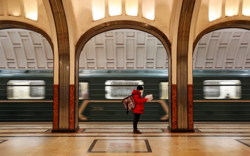 &copy; Reuters. Курьер в защитной маске на станции метро в Москве
