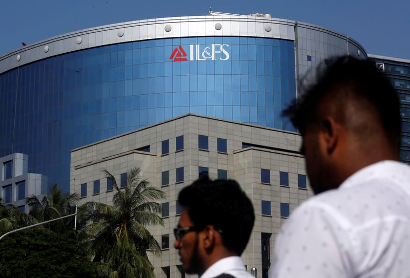 &copy; Reuters. People walk past a building of IL&amp;FS outside its headquarters in Mumbai